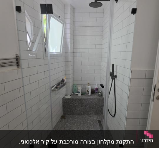 מקלחת עם דלת זכוכית ומוצרים על מדף
